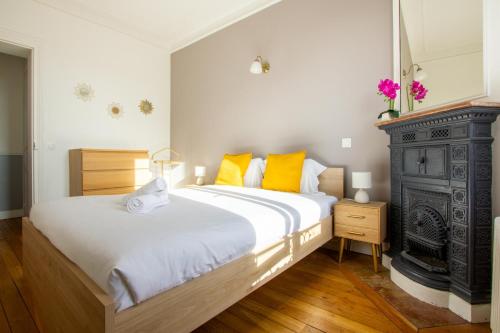 une chambre avec un grand lit avec des oreillers jaunes dans l'établissement Héritage Haussmannien - T2 de Charme, à Corbeil-Essonnes