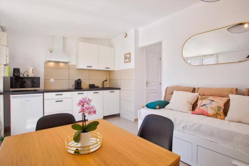 une cuisine et un salon avec une table et un canapé dans l'établissement L'atypique, avec terrasse à 150M de la plage, à Lion-sur-Mer