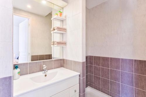 a bathroom with a sink and a mirror at L'atypique, avec terrasse à 150M de la plage in Lion-sur-Mer