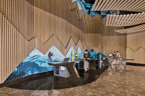 a room with tables and a mural of mountains on the wall at Crowne Plaza Shanghai Snow World by IHG in Shanghai