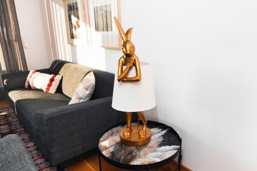 a gold statue on a table next to a couch at HEIMATEL - Bodensee Residenz Allgäu in Scheidegg