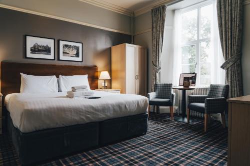 a hotel room with a bed and a table and chairs at The Coniston Inn - The Inn Collection Group in Coniston