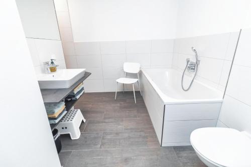 a bathroom with a sink and a tub and a toilet at HEIMATEL - Bodensee Residenz Allgäu in Scheidegg