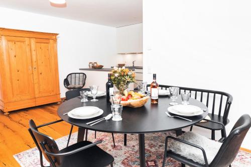 a black table with a bowl of fruit and a bottle of wine at HEIMATEL - Bodensee Residenz Allgäu in Scheidegg