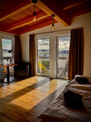 a bedroom with windows and a bed and a table at Hotel Rappenhof in Breuna