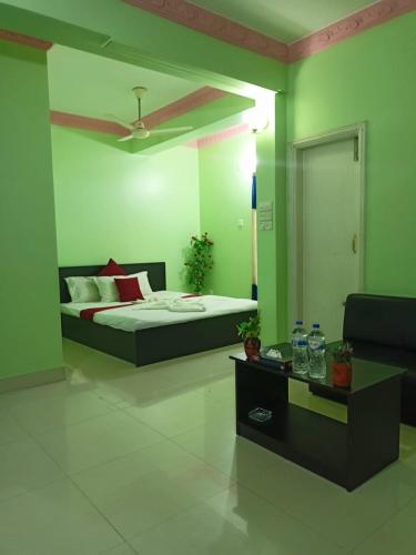 a bedroom with a bed with green walls at Grand Selim Resort & Tour – GSRT in Sreemangal