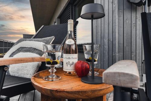 a bottle of wine and two glasses on a table at HEIMATEL - Bodensee Residenz Allgäu in Scheidegg