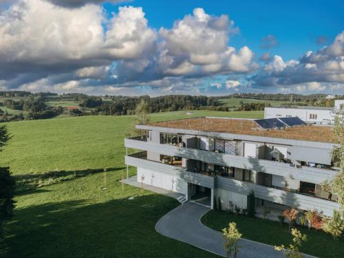 an aerial view of a building with a green field at HEIMATEL - Bodensee Residenz Allgäu in Scheidegg