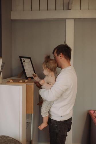 a man holding a child in front of a computer at Seaside Apartments Roja in Roja