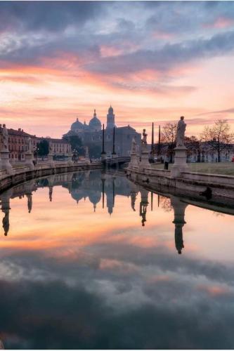 a reflection of a city in the water at sunset at Borghetto San Biagio Relais Agriturismo in Thiene