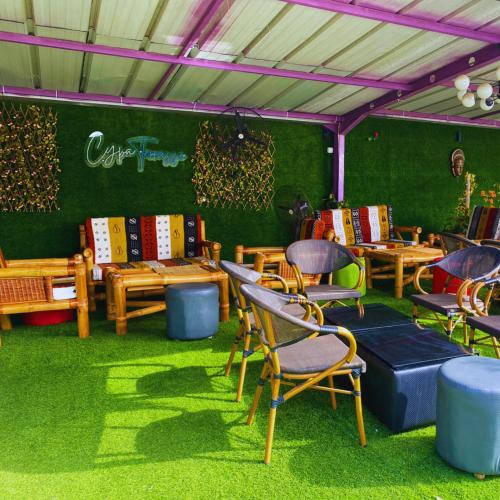 a room with chairs and tables on the grass at Cypa Hotel in Abidjan