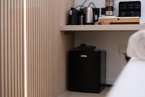 a small black refrigerator sitting under a shelf at "Versace" Luxury Suite in Centro Città, a 350m dal Mare, Scopri la tua offerta SPECIALE! in Pescara