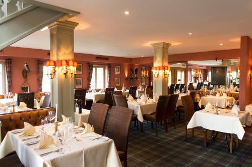 een eetkamer met witte tafels en stoelen bij Schloss Lüdersburg Golf & Spa in Lüdersburg