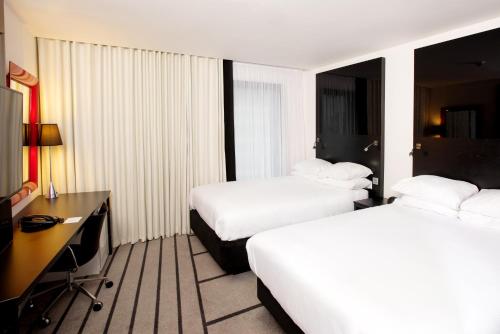 a hotel room with two beds and a desk at Crowne Plaza Manchester City Centre by IHG in Manchester