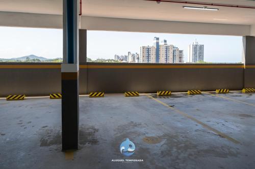 an empty parking lot with a view of a city at Apartamentos em Bal Piçarras 150 M DA PRAIA com Sacada Wi Fi, Piscina, Portaria 24h, Playground e vaga de GARAGEM in Piçarras