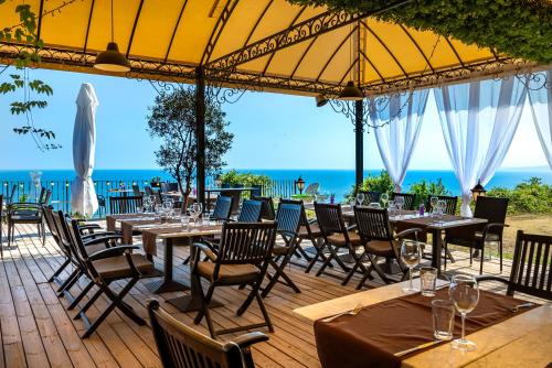 a restaurant with tables and chairs with the ocean in the background at Kaliakria Resort in Topola