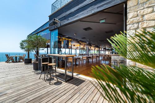 a restaurant with tables and chairs on a wooden deck at Kaliakria Resort in Topola