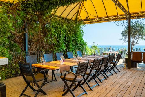 a long wooden table and chairs on a patio at Kaliakria Resort in Topola