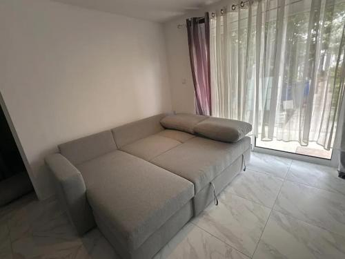 ein Wohnzimmer mit einer Couch vor einem Fenster in der Unterkunft Appartement accueillant près de Paris, 45 m², terrasse in Tremblay En France