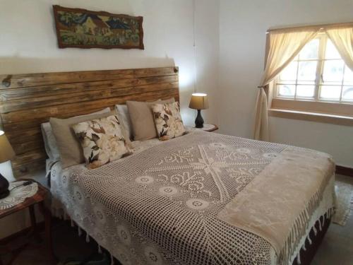 a bedroom with a large bed with a wooden headboard at Church Mouse House in Pilgrimʼs Rest