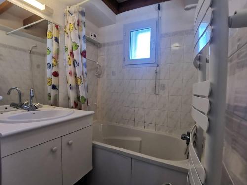 une salle de bain avec un lavabo et une baignoire dans l'établissement Carnac - Duplex T3 avec Piscine, 6 Couchages, Proche Plage - FR-1-377-58, à Carnac
