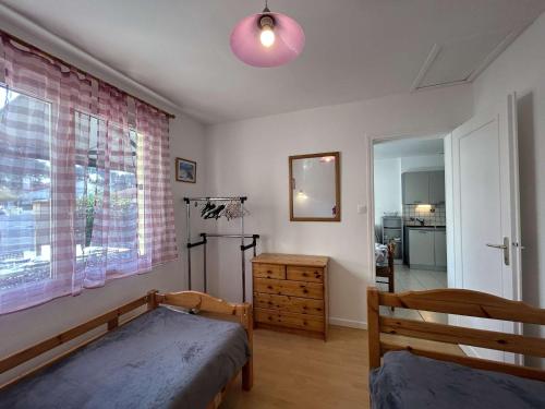 a bedroom with a bed and a dresser and a window at Maison de Vacances avec Terrasse Dallée, 6 Couchages, à Deux Pas de l'Océan à St-Jean-de-Monts - FR-1-224C-94 in Saint-Jean-de-Monts