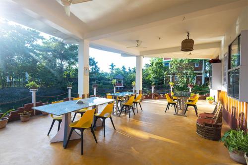 a patio with tables and chairs in a building at Manas Jungle Retreat in Jyoti Gaon