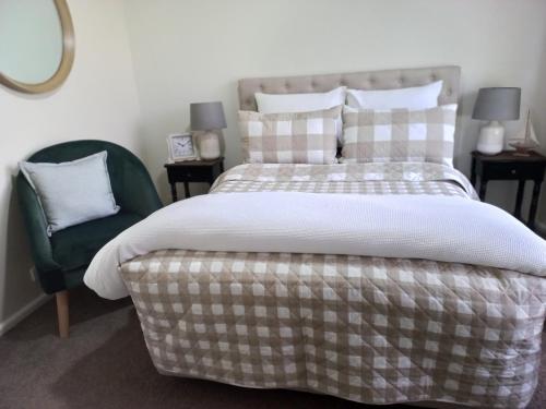 a bedroom with a bed and a chair at HUNTER COTTAGE EUROA - "A great weekend escape" in Euroa