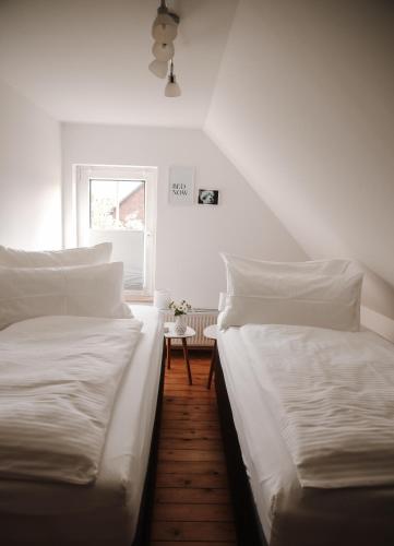 two twin beds in a room with a window at Freistehendes 4-Sterne Ferienhaus in der Uckermark in Haßleben