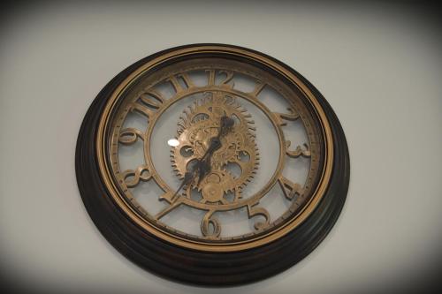 a gold clock is on a white wall at Hatfield Gem - 1 Bed with FREE Parking near Uni, Business Park & City Center, Big savings on Longer Stays in Hatfield