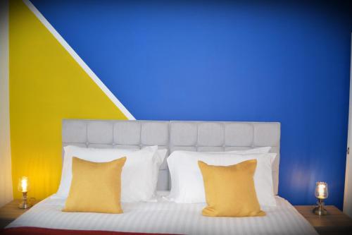 a bed with yellow pillows and a colorful wall at Hatfield Gem - 1 Bed with FREE Parking near Uni, Business Park & City Center, Big savings on Longer Stays in Hatfield
