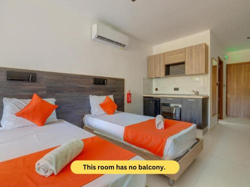 a room with two beds with orange pillows at Bayside A Apartments in St Julian's