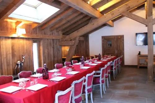 - une grande table avec des tables et des chaises rouges dans la chambre dans l'établissement LA DATCHA CHALET PISCINE HAMMAM SAUNA 25 personnes, à Champagny-en-Vanoise