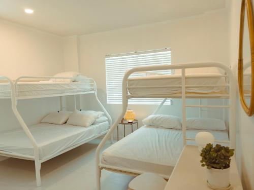 a room with two bunk beds and a window at Beachside Sunset Oasis at Canyon Cove in Nasugbu
