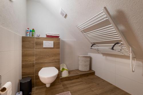 a small bathroom with a toilet and a staircase at Apartman u babky in Pavčina Lehota