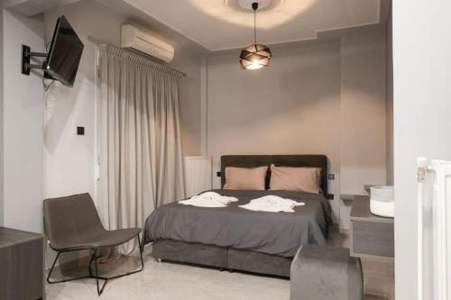 ドラマにあるMaybe Home suite apartments No2のベッドと椅子とテレビのある寝室