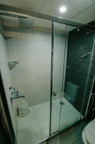 a bathroom with a glass shower with a toilet at Avoki Resorts in Trivandrum
