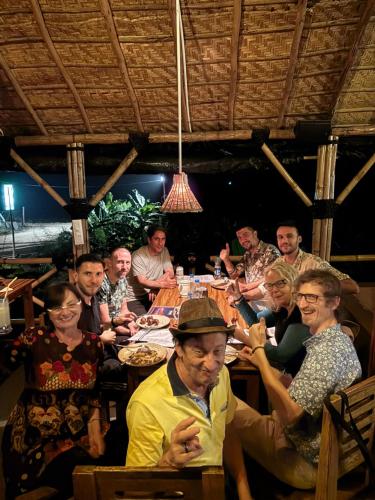 a group of people sitting around a table at Mowgli's Cafe Hampi & Guest House in Hampi