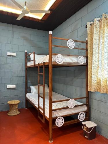 two bunk beds in a room with a blue wall at Mowgli's Cafe Hampi & Guest House in Hampi