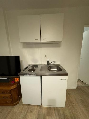 a small kitchen with a sink and a microwave at Möbliertes Zimmer mit TV, Internet & kompletter Ausstattung in Bonn-Mehlem in Bonn
