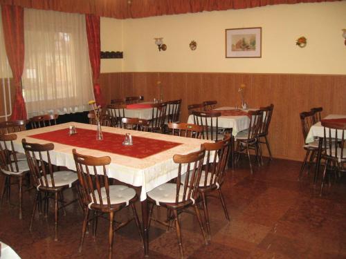 een eetkamer met tafels en stoelen. bij Hattyú Fogadó in Tata