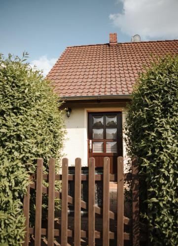 a house with a wooden fence in front of it at Freistehendes 4-Sterne Ferienhaus in der Uckermark in Haßleben