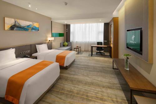 a hotel room with two beds and a television at Holiday Inn Chengdu Airport by IHG - Free Shuttle to Shuangliu International Airport in Chengdu
