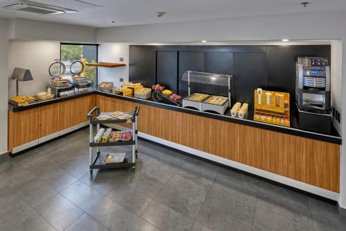a restaurant with a counter with food and a cash register at City Express by Marriott Tijuana Rio in Tijuana