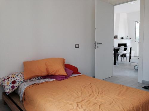 una camera con un letto e una coperta arancione di Villa Pierina ad Ardea