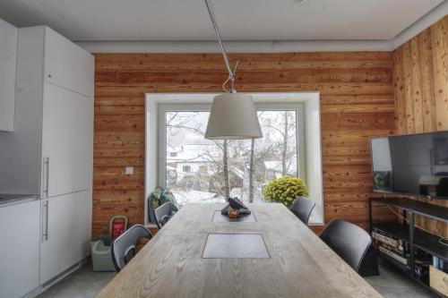 une salle à manger avec une table en bois et une fenêtre dans l'établissement Apartment Bonatti 202, à Chamonix-Mont-Blanc