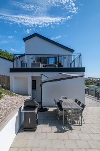 a patio with a grill and a table and chairs at BayView Luxury 4 Bedroom Villa in Downings