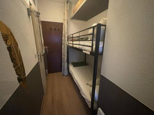 Cette petite chambre dispose de lits superposés et d'un couloir. dans l'établissement Studio Cabine au Centre des Angles avec Balcon, Casier à Skis, et Kitchenette Équipée - FR-1-593-86, aux Angles