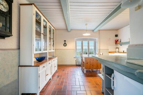 a kitchen with white cabinets and a tile floor at Ferienwohnung 4 Am Westerdeich in Rodenäs