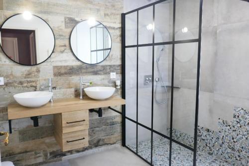 ein Badezimmer mit zwei Waschbecken und zwei Spiegeln in der Unterkunft Grande Maison 200m de la plage à Bretignolles Mer plus piscines partagées in Brétignolles-sur-Mer